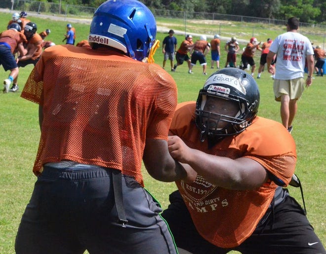 Lakeland lineman Alex Edward, left,  works on his technique with a fellow camper Wednesday at the Down and Dirty lineman camp at Webber University in Babson Park.