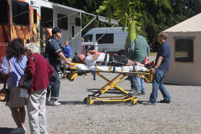 Mt. Shasta Ambulance brings a “victim” on a stretcher to the Incident Command Center, which was staged at the Evangelical Free Church Wednesday afternoon during the Upper Sacramento River Hazardous Materials training drill.