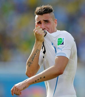 Uruguay's Jose Maria Gimenez kisses his shirt following Uruguay's 1-0 victory over Italy during the group D World Cup soccer match at the Arena das Dunas in Natal, Brazil, Tuesday, June 24, 2014.