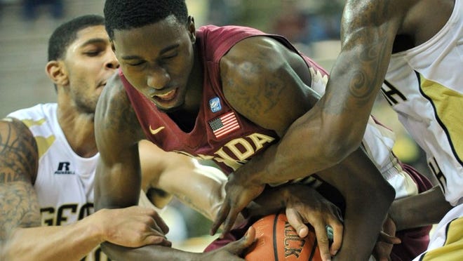 Florida State’s Okaro White (middle) battles Georgia Tech’s Lance Storrs (left) and Iman Shumpert for a rebound during an ACC contest in 2011. (Hyosub Shin, hshin@ajc.com)
