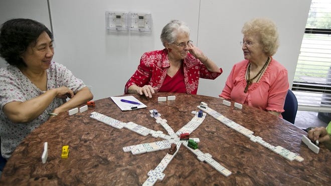 From left, Kim Nguyen, Margaret Hughes and Iola Canady share a laugh while playing dominoes at the South Austin Senior Activity Center.