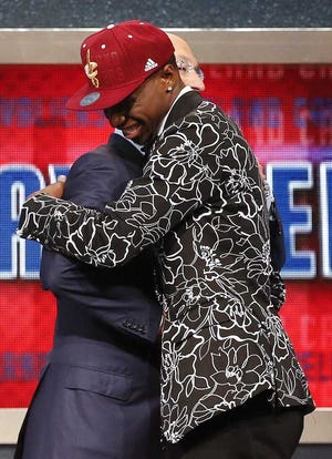 NBA Commissioner Adam Silver, left, congratulates Andrew Wiggins of Kansas who was selected by the Cleveland Cavaliers as the number one pick in the 2014 NBA draft, Thursday, June 26, 2014, in New York. (AP Photo/Jason DeCrow)