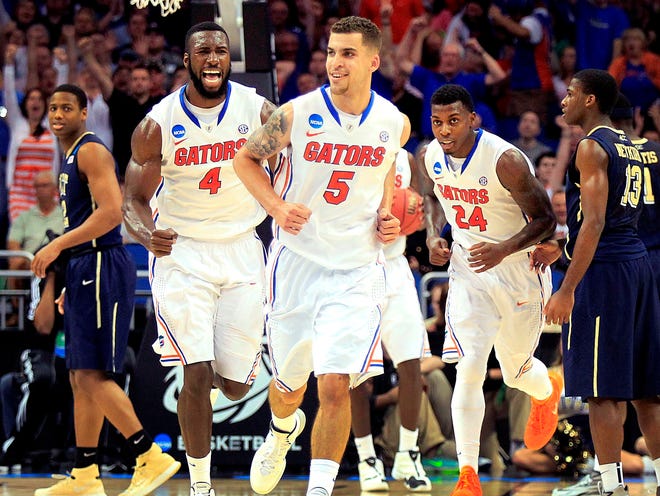 Florida guard Scottie Wilbekin (5) celebrates as he runs off the court with center Patric Young (4) and forward Casey Prather (24) after hitting a three as time expired in the first half of a third-round game in the NCAA tournament against Pittsburgh on March 22 in Orlando.