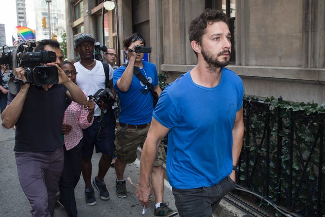 Actor Shia LaBeouf walks through the media after leaving Midtown Community Court following his arrest the previous day for yelling obscenities at a Broadway performance of "Cabaret", Friday, June 27, 2014, in New York. The 28-year-old, who starred in the first three "Transformers" movies, was arrested on charges of disorderly conduct and criminal trespass. He's due back in court July 24. (AP Photo/John Minchillo)
