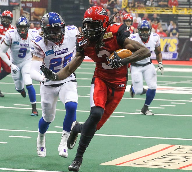 Sharks' Jeron Harvey (3) runs for a touchdown after the catch pursued by Thunder's Bryce Peila (20) during the first quarter Saturday. Arena Football League Jacksonville Sharks hosted the Portland Thunder at Jacksonville Veterans Memorial Arena Saturday, April 26, 2014, Jacksonville.