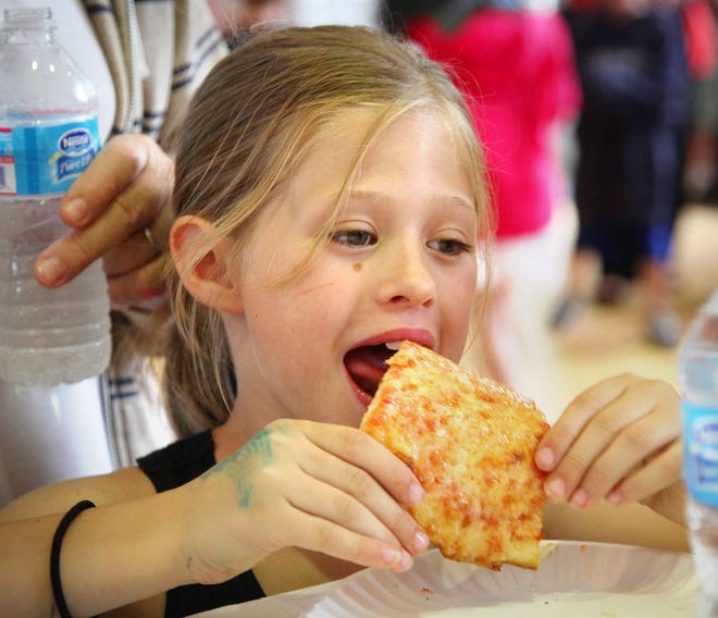 Isalina Ackerman, 7, of Braintree, tries a slice at Pizza Palooza, an event held at Braintree Town Hall on Thursday, June 26, 2014, to raise money for the town's Fourth of July celebration.