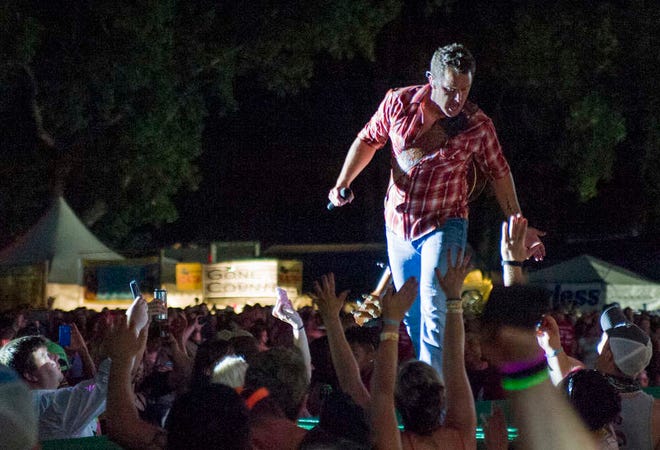 Easton Corbin high fives fans in the party pit as he makes his way back to the main stage on Thursday, June 26, 2014 at the Kicker Country Stampede in Manhattan.