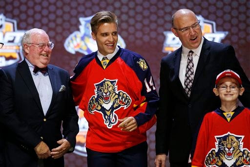 Aaron Ekblad stands with Florida Panthers officials after being chosen first overall during the first round of the NHL hockey draft, Friday, June 27, 2014, in Philadelphia.
