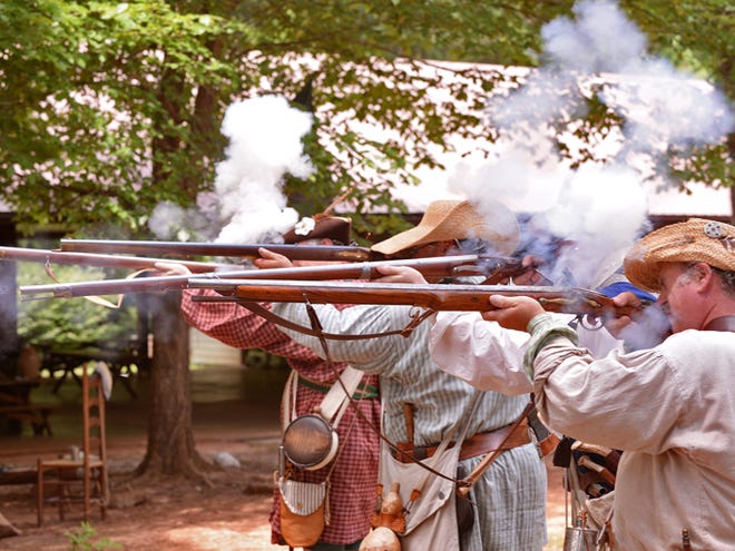 South Carolina Independent Rangers fire their rifles during a demonstration at Walnut Grove Plantation on Saturday afternoon. Re-enactors, including (from left to right) Stephen Nendick, Tim Foster, Robert Hall, and John Moss encamp at the historic plantation and share their knowledge of the important role that Spartanburg County held in America's War for Independence.