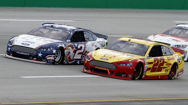 Brad Keselowski (2) and Joey Logano (22) vie for the lead in the NASCAR Sprint Cup series auto race Saturday, June 28, 2014, at Kentucky Speedway in Sparta, Ky. (AP Photo/James Crisp)