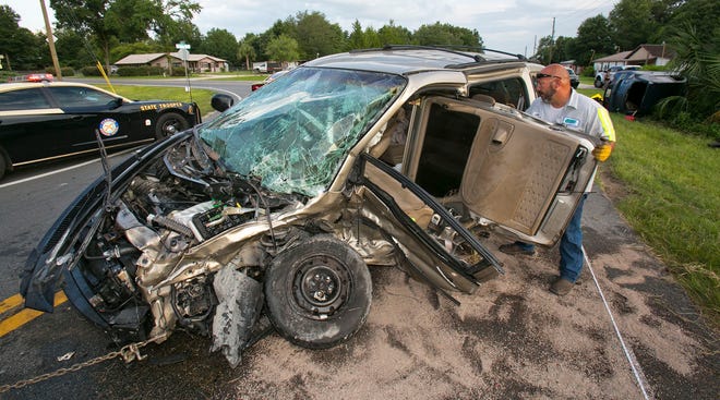 Tow Truck Driver Cooter Wisdom with Daves Towing, stuffs the sliding side door of the van into the passenger compartment at the scene of a fatal head on collision that occurred at the intersection of E. Hwy. 316 and N.E. Jacksonville Road in Citra, FL, Saturday evening June 28, 2014. A Mazda Speed 3 was heading North when the driver crossed the center line striking a Chrysler Voyager head on. The driver of the Mazda was pronounced dead at the scene while the driver of the van was transported to a local hospital and reported in serious condition.