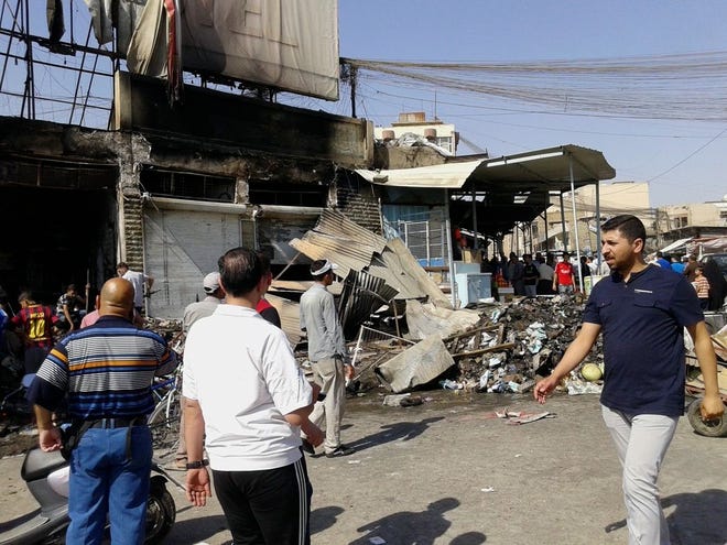 People inspect buildings damaged by an Iraqi government airstrike in the northern city of Mosul, Iraq, Saturday, June 28, 2014. The Iraq military carried out three airstrikes on the insurgent-held city of Mosul early Saturday. (AP Photo)