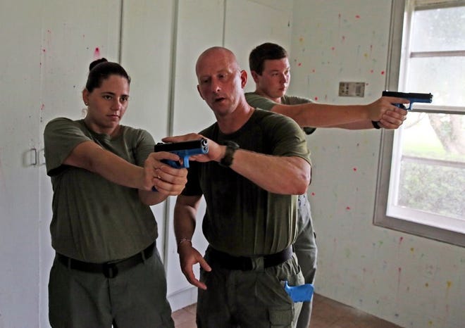Aylin Diaz receives pistol instruction from Broward sheriff's Deputy Michael Brady, while Robert Choate aims at a target. The Explorers trained at an old state mental hospital in Pembroke Pines.
