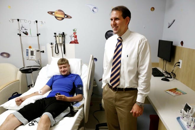 Dr. Michael Haller, an associate professor with the University of Florida Department of Pediatric Endocrinology, visits with Type I diabetes patient Ryan Moss, 15, and talks about his research. 
HALIFAX MEDIA SERVICES