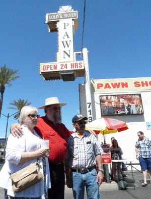 Mark Hall-Patton, center, poses for photos with fans outside the pawn shop featured on "Pawn Stars" in Las Vegas. Hall-Patton, the curator of the Clark County Museum, appears regularly on the show authenticating items brought into the shop.