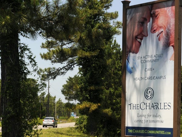 A sign advertising for The Charles development just off northeast of N.C. 211 near Midway Road is shown on June 18, 2014. The 2,100 acres development in Brunswick County is expected to be a mixed-use community catering to seniors and their health care needs. Photo by Jason Gonzales