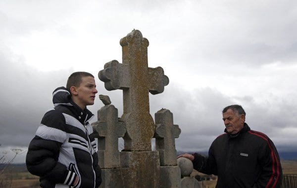 Nikola Princip, right, pays his respects at the family cemetery plot in Obljaj, Bosnia, with his grandson Novak, left. Nikola Princip is a nephew of Gavrilo Princip, who in 1914 assassinated the Austro-Hungarian crown prince, an incident considered the spark for World War I.