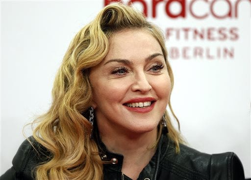 FILE - In this Oct. 17, 2013, file photo, U.S. pop star Madonna smiles during her visit at the "Hard Candy Fitness" center in Berlin. Madonna attended a preview of "Holler If Ya Hear Me" in New York City on Monday, June 16, 2014, which would have been the her friend and rapper Tupac Shakur's 43rd birthday. Shakur died in 1996 at age 25. (AP Photo/Michael Sohn, File)