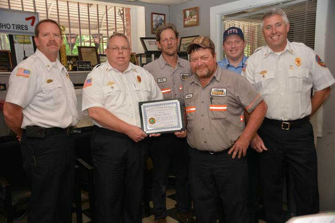 Courtesy of Randy Hunter Chief John Thompson presents the owner of Tommy's Towing, Tommy Burrows, with a certificate of appreciation for the company's quick response and assistance in regards to a motor vehicle accident.