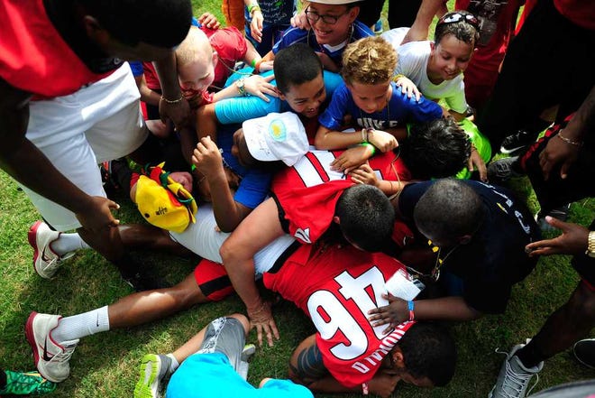Campers and football players pile on Blake Tibbs after a touchdown catch during a pickup game at Camp Sunshine on Wednesday, July 2, 2014, in Rutledge, Ga. (AJ Reynolds/Staff, @ajreynoldsphoto)