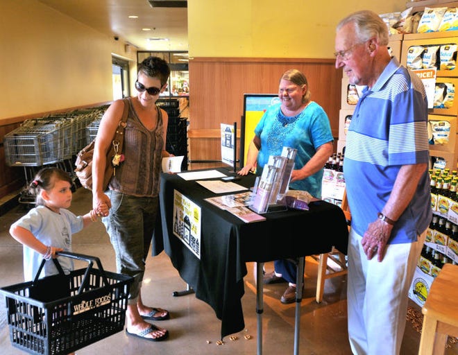 Wes Kennedy, right, Vice President of Community of Hope NJ, and Sharon Daly Christenson, second from right, talk with Evesham resident Kyra Carver and her daughter, Margueritte at the Whole Foods store in Evesham about the program that Whole Foods will donate 5% of Wednesday's sales to Citizens Serving the Homeless.