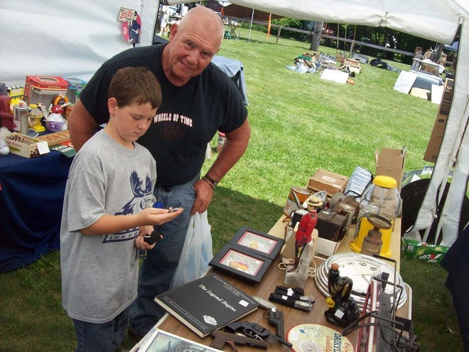 J.T. Passolt, 10, left, and his grandfather Peter French check out some of the vintage tractor items during the antique car show and swap meet on June 27 in Bouckville.