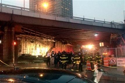 This photo provided by Roberto Danino shows emergency personal near a section of the facade inside an underpass of the Brooklyn Bridge after it had collapsed, Wednesday, July 2, 2014, in the Brooklyn borough of New York. A fire department spokesman says five people were injured. (AP Photo/Roberto Danino)