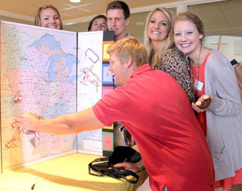 Clockwise from top left: Heather Moix, Reece Phillips, Nate Booth, Alex Shaffer, Courtney Briggler, and Granger Riggins pose in front of a map showing where Kaleo members are from.