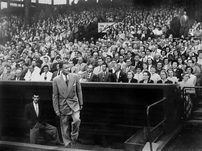 The Rev. Billy Graham emerges from the Pirates dugout at Forbes Field to deliver a sermon in his first visit to Pittsburgh. Four years earlier, a revival in
Altoona had left him so despondent, he wrote in his 1997 memoir, “Just As I Am,” that he questioned his mission.