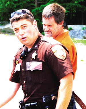 An officer with the Rockingham Sheriff's Department leads Anthony Reardon from Seabrook District Court after his probable cause hearing was rescheduled to July 10. Reardon allegedly stole and crashed police cruisers during an armed confrontation with officers last month.