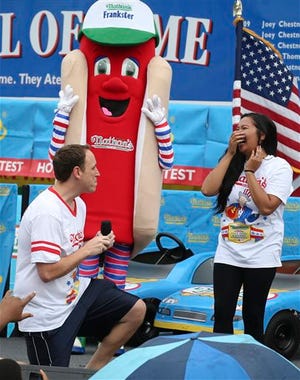 Competitive eater Joey Chestnut proposes Friday to his girlfriend and fellow competitor Neslie Ricasa before the Nathan's Famous Fourth of July International Hot Dog Eating contest at Coney Island.