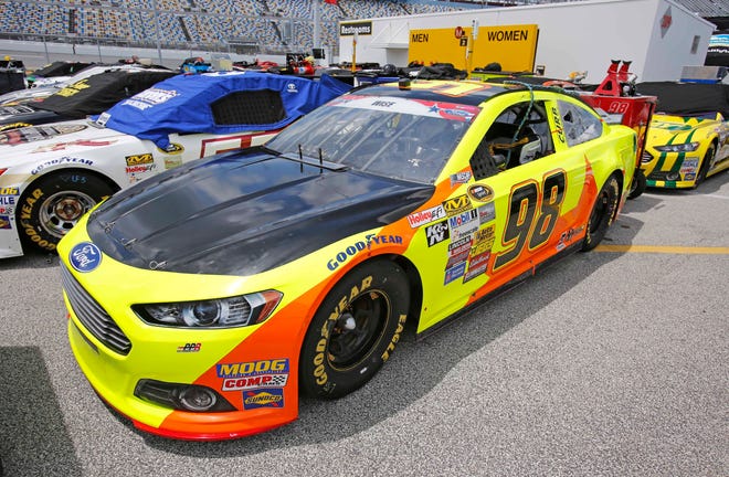 Crew members push the No. 98 car of Josh Wise from one inspection station to the next, Friday, July 4, 2014, at Daytona International Speedway in Daytona Beach, Fla. Decals bearing the name of Democratic gubernatorial candidate Charlie Crist had been removed from the car.