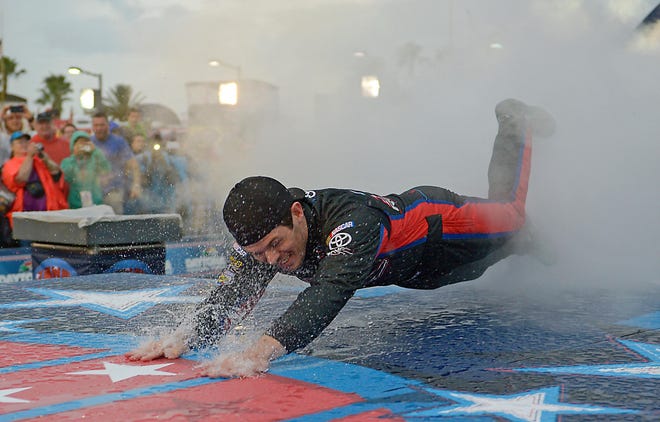 Ryan Truex dives on the rain-slick runway during introductions before the Coke Zero 400 at Daytona International Speedway in Daytona Beach, Fla., Saturday.