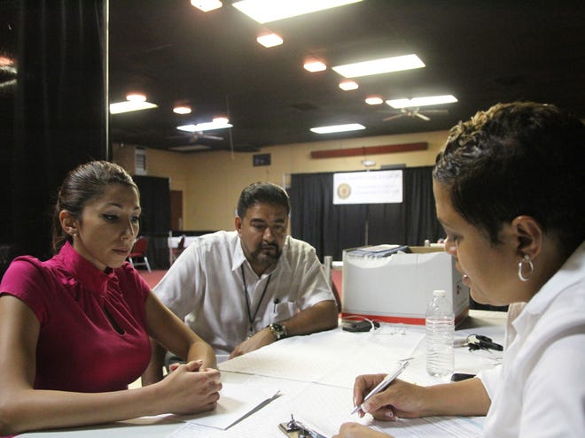 In this June 27, 2014 photo, veteran Rebecca King, left, talks with Veterans Affairs employee Joe Esparza, center, and American Legion official Verna Jones at the American Legion in El Paso, Texas.The American Legion is hosting crisis centers in different cities to help veterans get doctorÃ­s appointments and benefits from the Department of Veterans Affairs.
