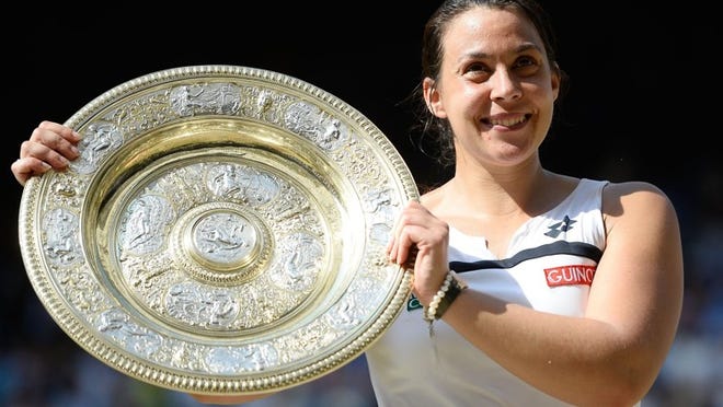 Marion Bartoli of France poses with the Venus Rosewater Dish trophy after her victory in the women’s singles final at Wimbledon on July 6, 2013. A little more than a year after winning her sole Grand Slam title, Bartoli will begin play with the Austin Aces, a newcomer to World TeamTennis. CREDIT: Dennis Grombkowski/Getty Images