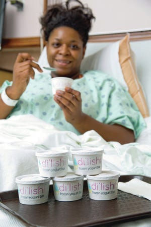 GOOD FOR YOU — Tammy Davis dips into a cup of di’lishi frozen yogurt at Randolph Hospital last week. The new offering was added as a menu option on July 1. (Josh Rasmussen/Randolph Hospital)