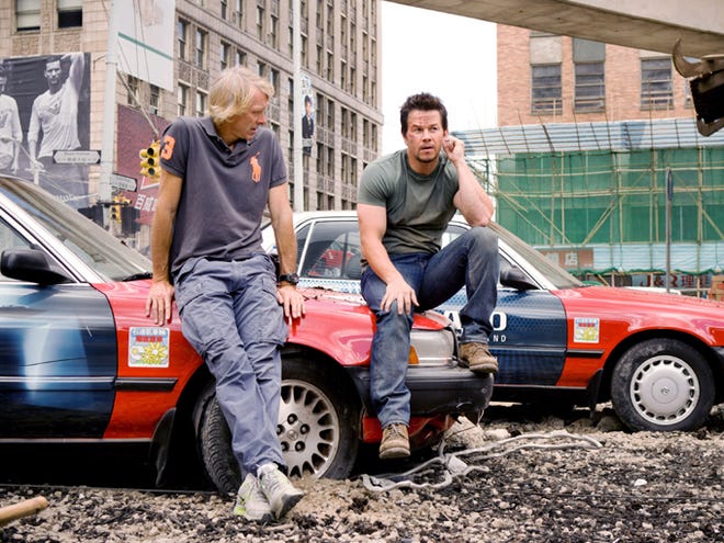 Director/Executive Producer Michael Bay, left, discusses a scene with Mark Wahlberg (who plays Cade Yeager) on the Detroit set of "Transformers: Age of Extinction."