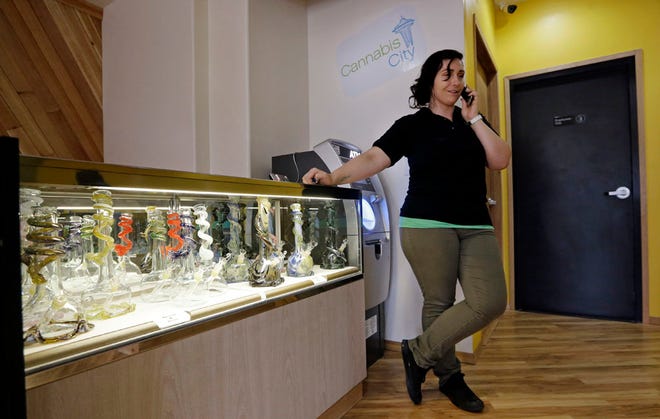 Cannabis City manager Amber McGowan takes the marijuana shop's first call, from a potential customer, days before the grand opening Wednesday, July 2, 2014, in Seattle. The store expects to begin selling pot Tuesday, July 8, the first day that recreational marijuana can legally be sold in Washington state and is expected to be the first licensed retailer in Seattle.