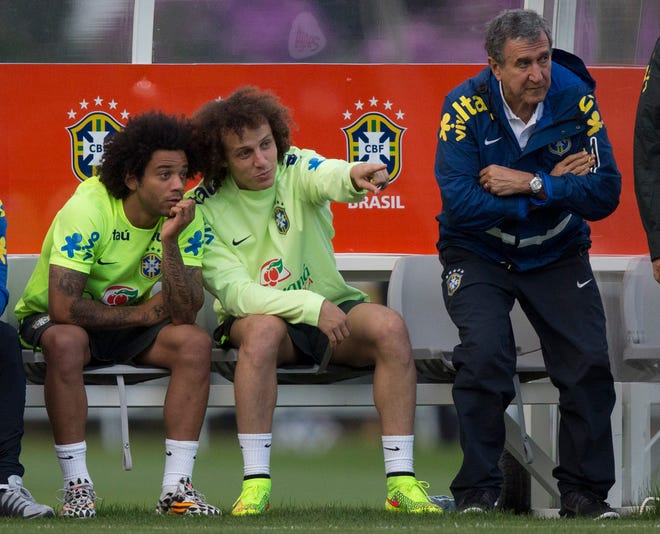 Brazil national soccer team members, David Luiz, center, talks with Marcelo, left, as the Brazil’s team coordinator Carlos Alberto Parreira stands next to them, during a practice session at the Granja Comary training center, in Teresopolis, Brazil, Sunday. Brazil will face Germany in their World Cup semifinals’ match, without superstar soccer player Neymar.