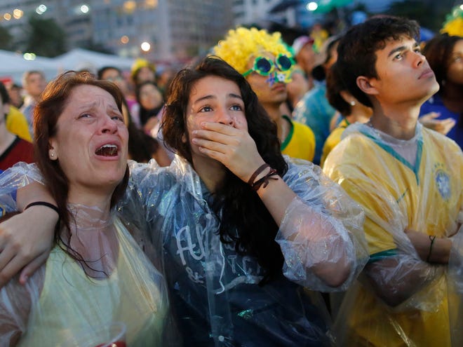 Brazil soccer fans cry as they watch their team play a World Cup semifinal match against Germany on a live telecast inside the FIFA Fan Fest area on Copacabana beach in Rio de Janeiro, Brazil, Tuesday, July 8, 2014. (AP Photo/Leo Correa)