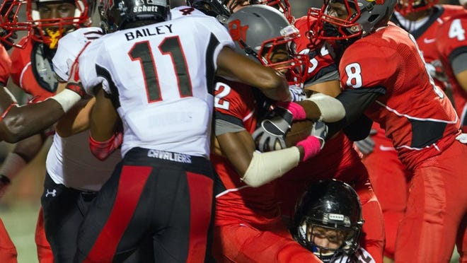James Bailey (11) stops Altany Wilson (2) during the 47-7 win by the Cavaliers over the Cardinals at Del Valle in 2013. Del Valle returns a lot of speed in the skill positions and could be a sleeper in 2014.