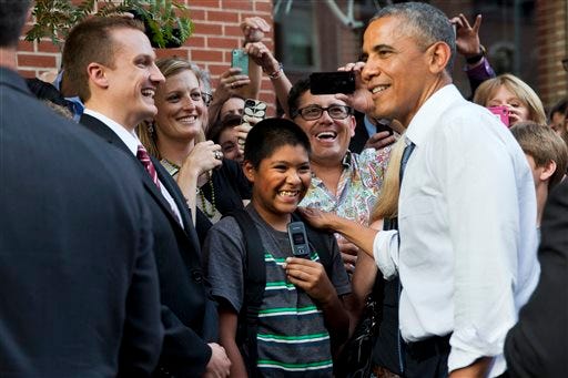 President Barack Obama greets an enthusiastic crowd during an impromptu walk down 15th Street after having dinner at Wazee Supper Club on Tuesday, July 8, 2014, in Denver.