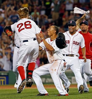 Boston Red Sox's Brock Holt (26) celebrates with teammates including Mookie Betts, front center, and Xander Bogaerts, second from right, after he hit an RBI single to win a baseball game against the Chicago White Sox 5-4 at Fenway Park in Boston, Wednesday, July 9, 2014.