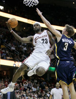 FILE - In this March 11, 2007, file photo, Cleveland Cavaliers' LeBron James (23) jumps high toward the basket against Indiana Pacers' Troy Murphy (3) during the second quarter in an NBA basketball game in Cleveland. James told Sports Illustrated on Friday, July 11, 2014, he is leaving the Miami Heat to go back to the Cleveland Cavaliers. (AP Photo/Tony Dejak, File)