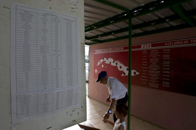 In this July 3, 2014, photo, prices are display at a car dealership that sells used vehicles in Havana, Cuba. With just 50 vehicles rolling off the lots of state-run dealerships in the first six months since the passing of a new law that allows Cubans to buy vehicles from the government without a special permit, and with 400 percent markups on the price the vehicles, it's easy to see the policy as a failure. But analysts say it seems to be working exactly as designed: To sell as few cars as possible. (AP Photo/Franklin Reyes)