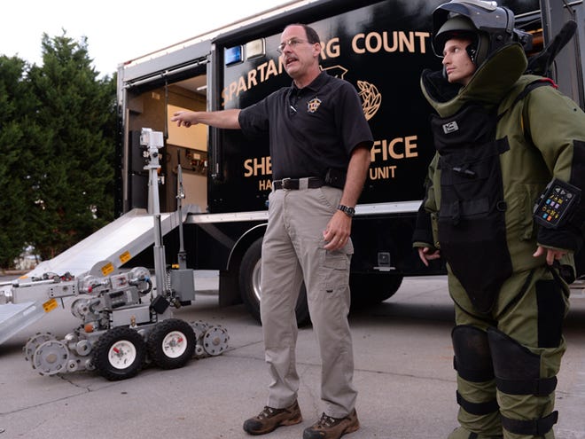 Lt. John Dyas, left, Lt. Ashley Harris, center, and detective Micah Horton present information to members of the Spartanburg County Sheriff's Office Citizen's Academy on Thursday. Dyas, center, demonsrates the use of a bomb technician suit with Herald-Journal reporter Daniel Gross, right.