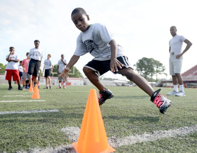 Isaiah Johnson, 8, runs drills on Saturday during a free football camp at Steve Riggs Stadium in Fort Walton Beach.