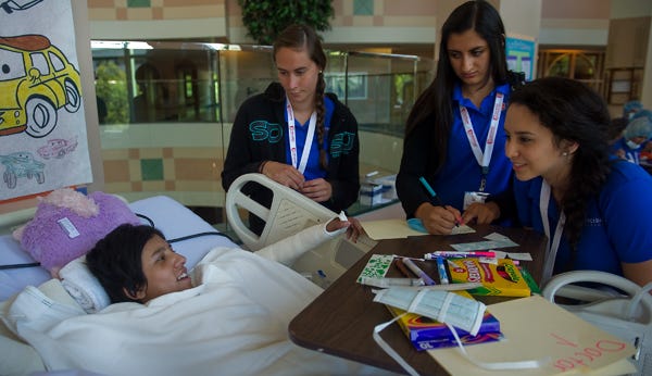 San Joaquin County high school students in the Decision Medicine program, from left, Gracie Ferguson, Kendahl Montanez and Melissa Garcia, all 17, talk with 13-year-old patient Anahi on Friday at the Shriners hospital in Sacramento.
