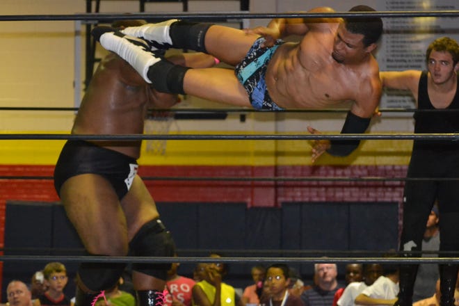 Pro wrestler ATL applies a flying sidekick to Team Sexy during Saturday’s High Volume Pro Wrestling Mega Show at the Salvation Army in Kinston.