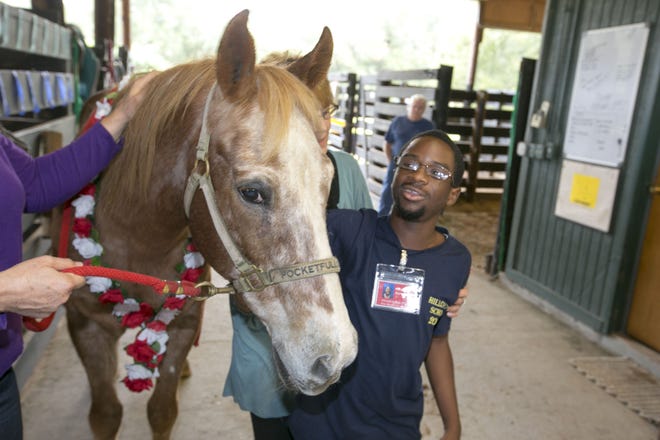 Hillcrest student Cory Guyton spends a moment with Spot during his retirement party at Marion Therapeutic Riding Association in Ocala, FL on Tuesday November 26, 2013. Spot, 25, has been giving students rides for seven years. He got a special horse cake and lots of love from past students.